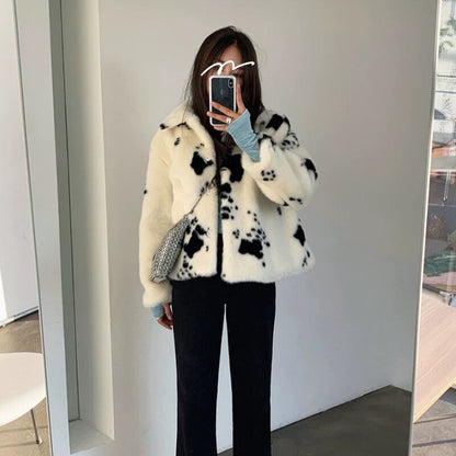 Frau in weiß-schwarzer Kunstpelzjacke, schwarze Hose, Spiegel-Selfie, modisch, Winterkleidung.