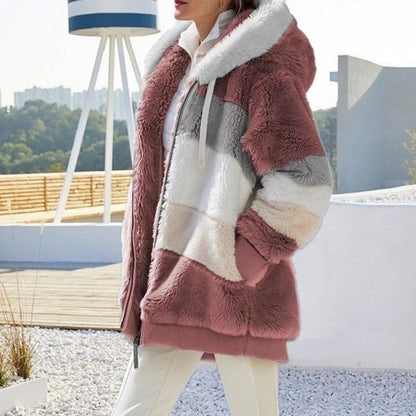 Frau in rosa-weißem Kunstpelzmantel mit Kapuze, modisch, warm, Winterkleidung, draußen.
