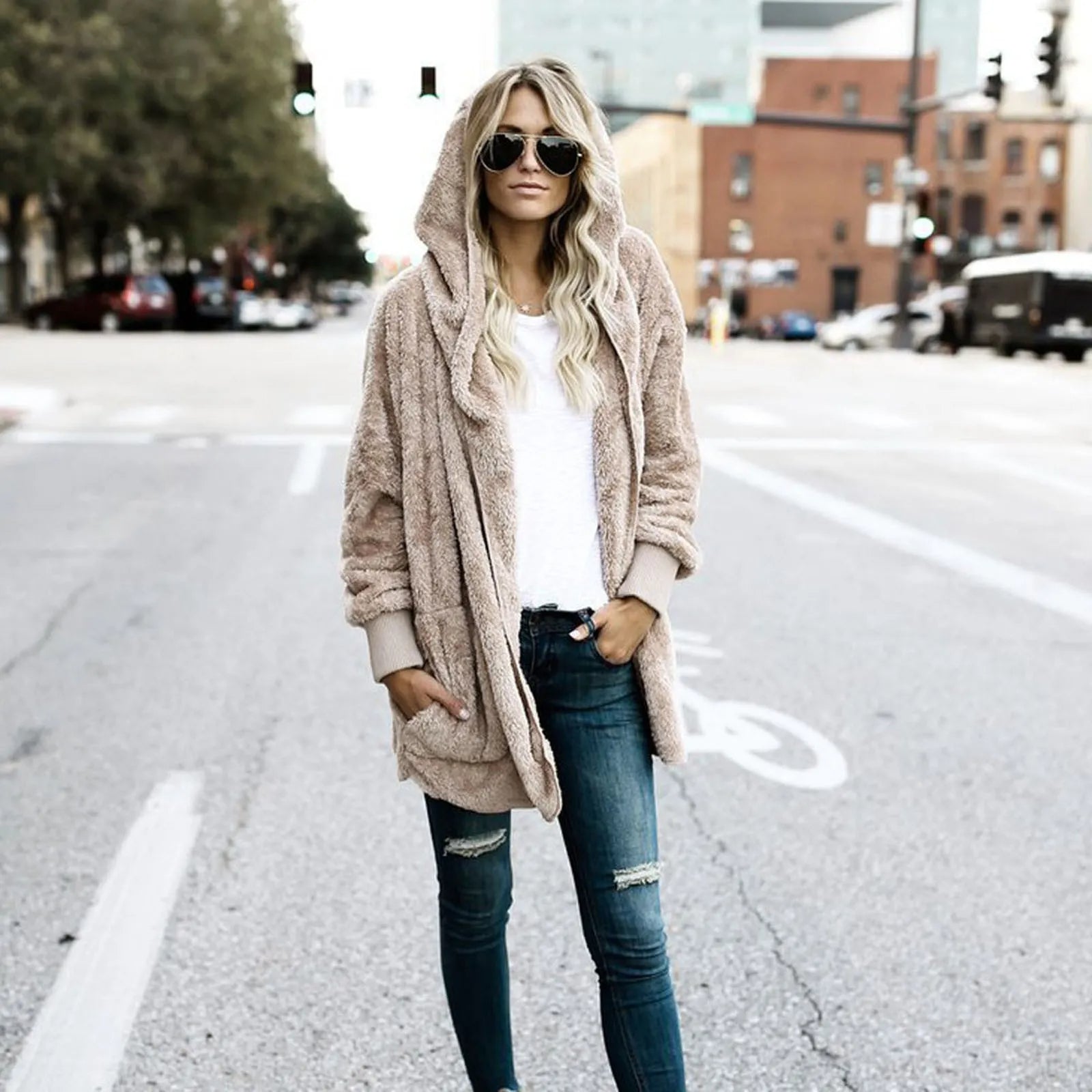 Frau in beiger Teddyjacke und Sonnenbrille auf Stadtstraße, lässiger Herbstlook.