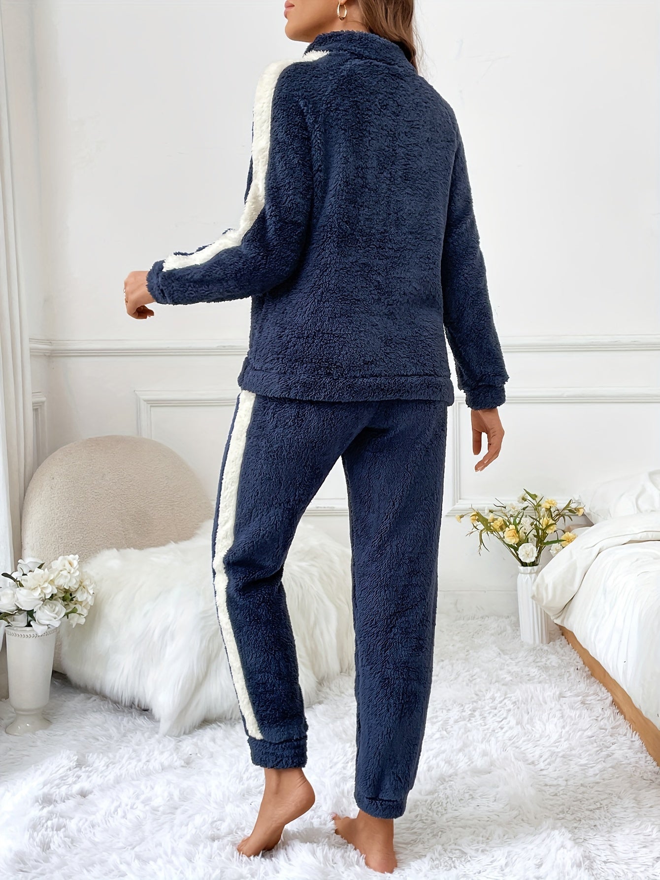 Frau in dunkelblauem Fleece-Trainingsanzug mit weißen Streifen, gemütlich, modern, modisch.