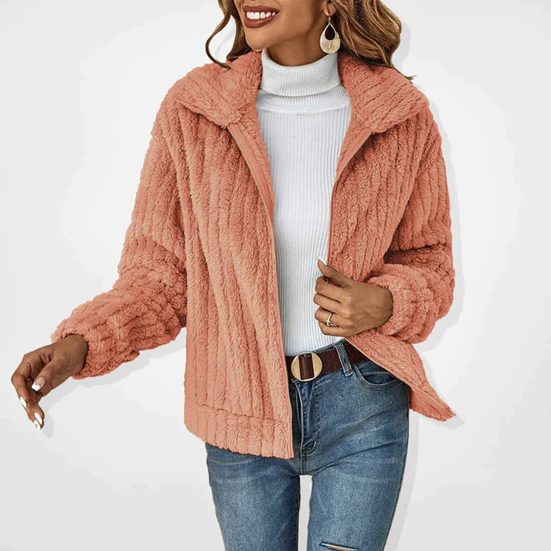 Frau in rosa Plüschjacke, weißem Rollkragenpullover und blauer Jeans, modisch, Herbstkleidung.