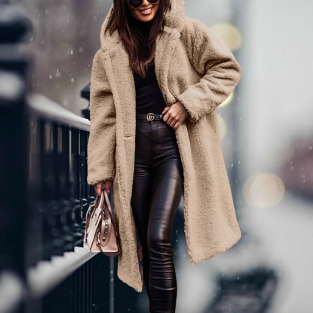 Frau in beigem Teddy-Mantel, schwarze Lederhose, Wintermode, stilvoll, urbaner Hintergrund.