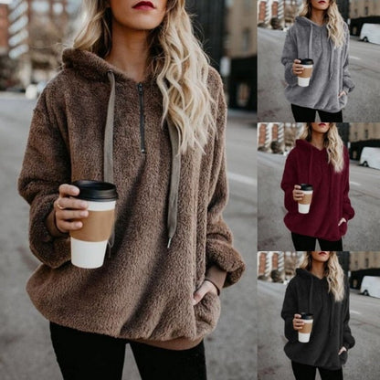 Frau in braunem Fleece-Hoodie mit Kaffeebecher, Herbstmode, gemütlicher Kapuzenpullover.