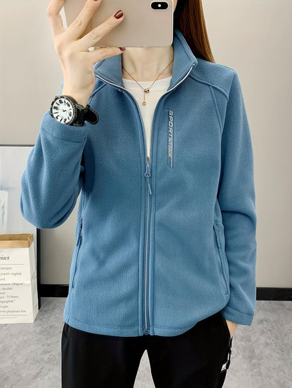 Frau in blauer Fleecejacke mit Reißverschluss, Sportuhr, lässiger Stil, Innenaufnahme.