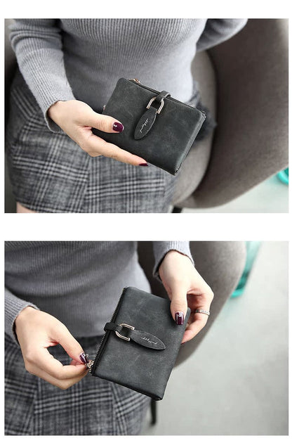 Damenhandtasche aus schwarzem Leder, kompakt, mit Reißverschluss und Schnalle, elegant.