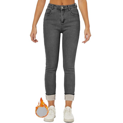 Graue Damenjeans, hoch tailliert, mit umgeschlagenem Saum und weißem Sneaker, modisch.