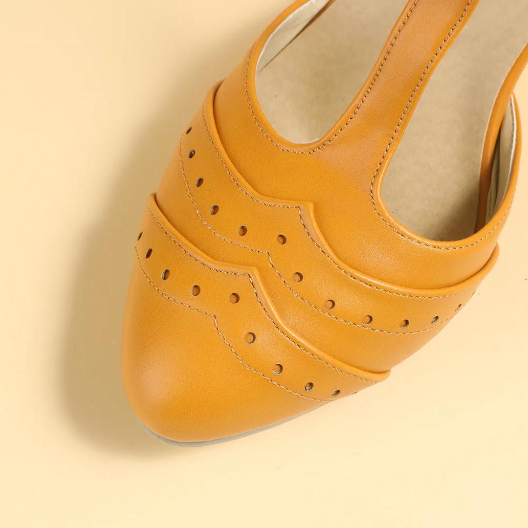 Gelber Lederschuh mit Lochmuster, elegantes Design, Damenmode, Nahaufnahme.
