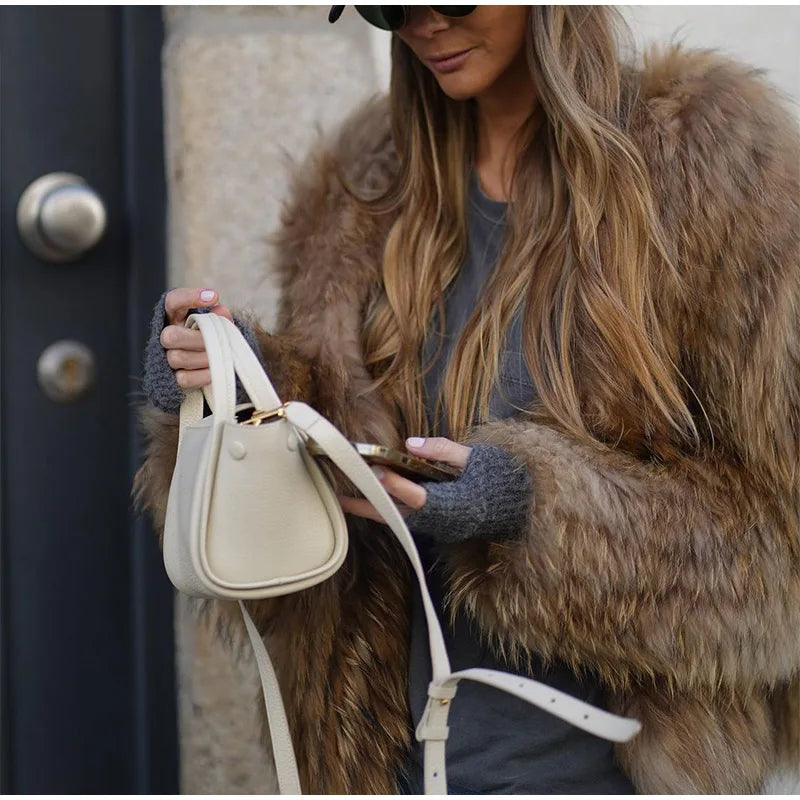 Frau mit braunem Pelzmantel und weißer Ledertasche, modisch, urbaner Stil.
