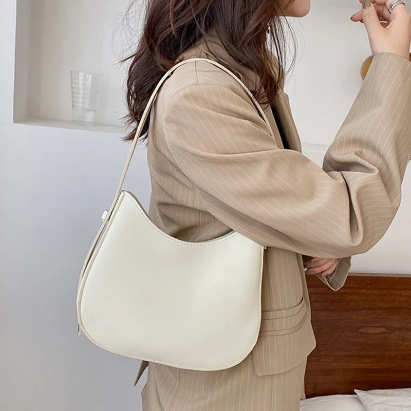 Frau mit cremeweißer Lederhandtasche, elegantes Design, modisches Accessoire, Bürooutfit.
