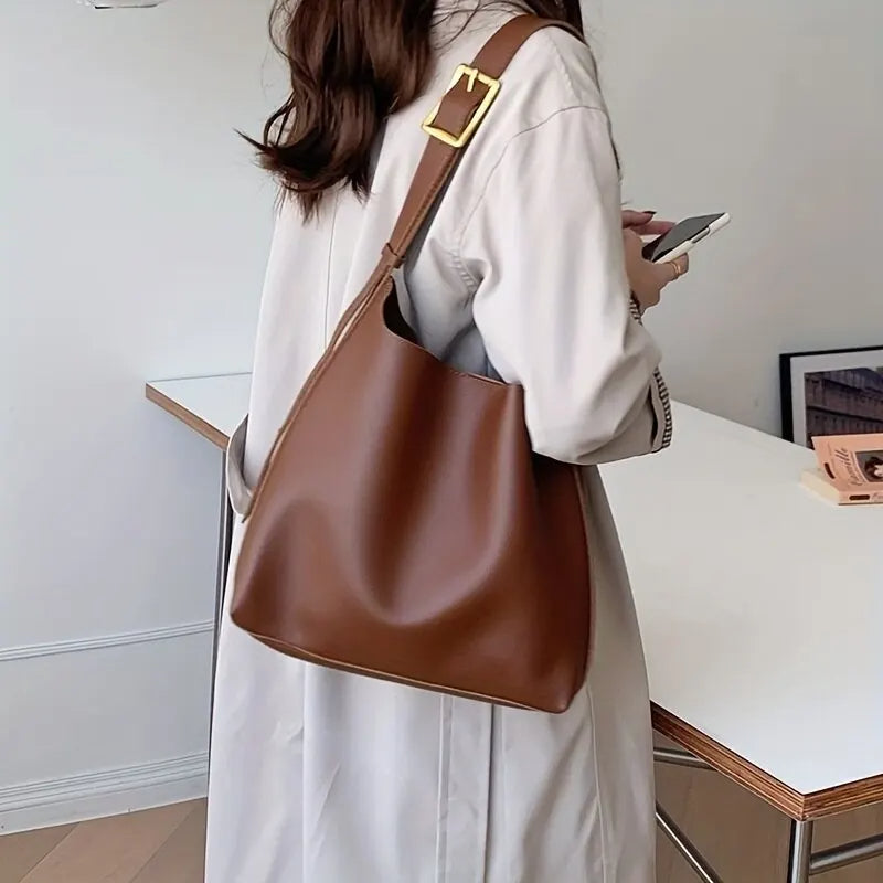 Frau mit brauner Ledertasche, Trenchcoat, Smartphone, modernes Design, eleganter Stil.