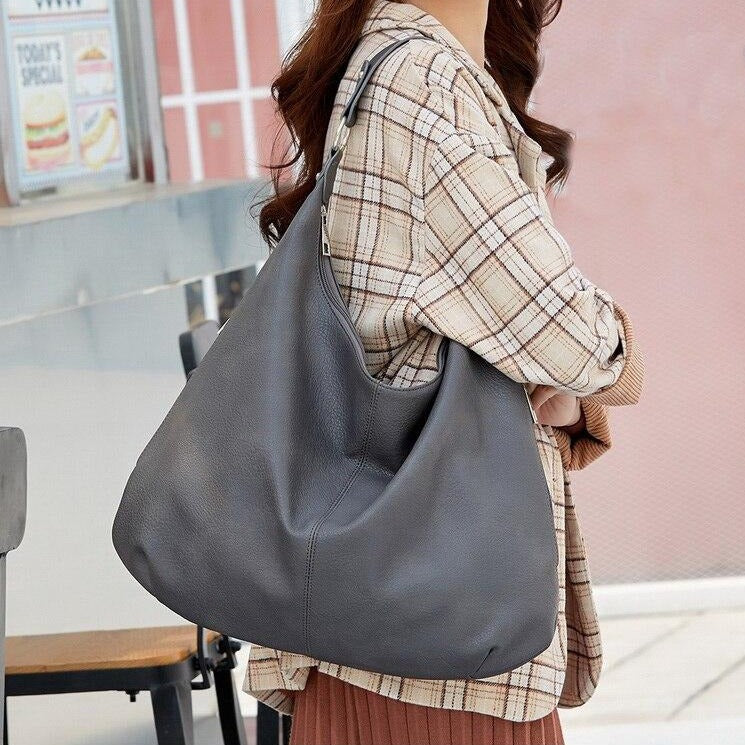 Frau mit grauer Lederhandtasche, lässiger Stil, modisches Accessoire, Herbstmode.