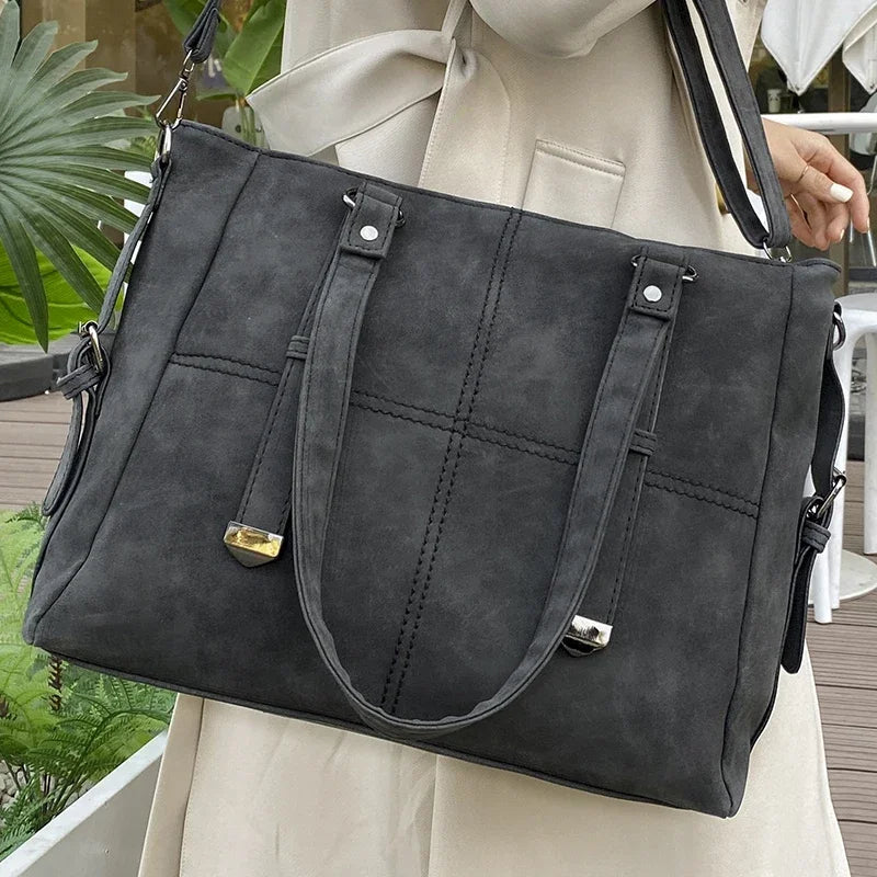 Dunkelgraue Damenhandtasche aus Leder mit Schulterriemen, elegant und geräumig.