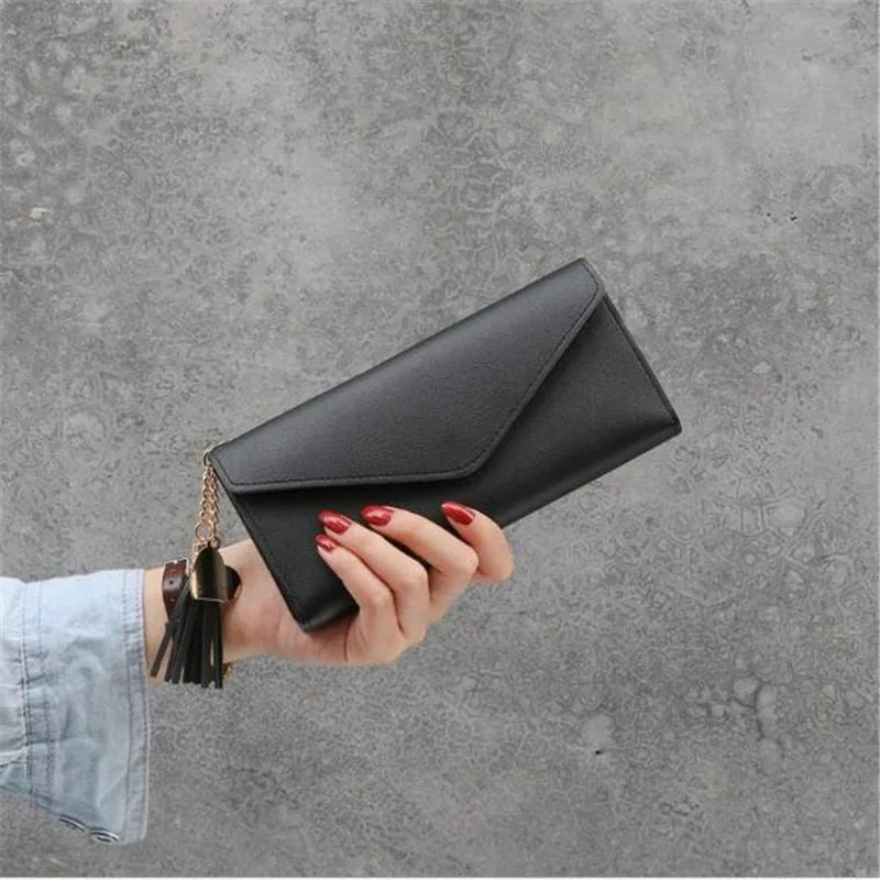 Damenhandtasche schwarz Leder, Clutch mit Quaste, elegantes Design, modisches Accessoire.