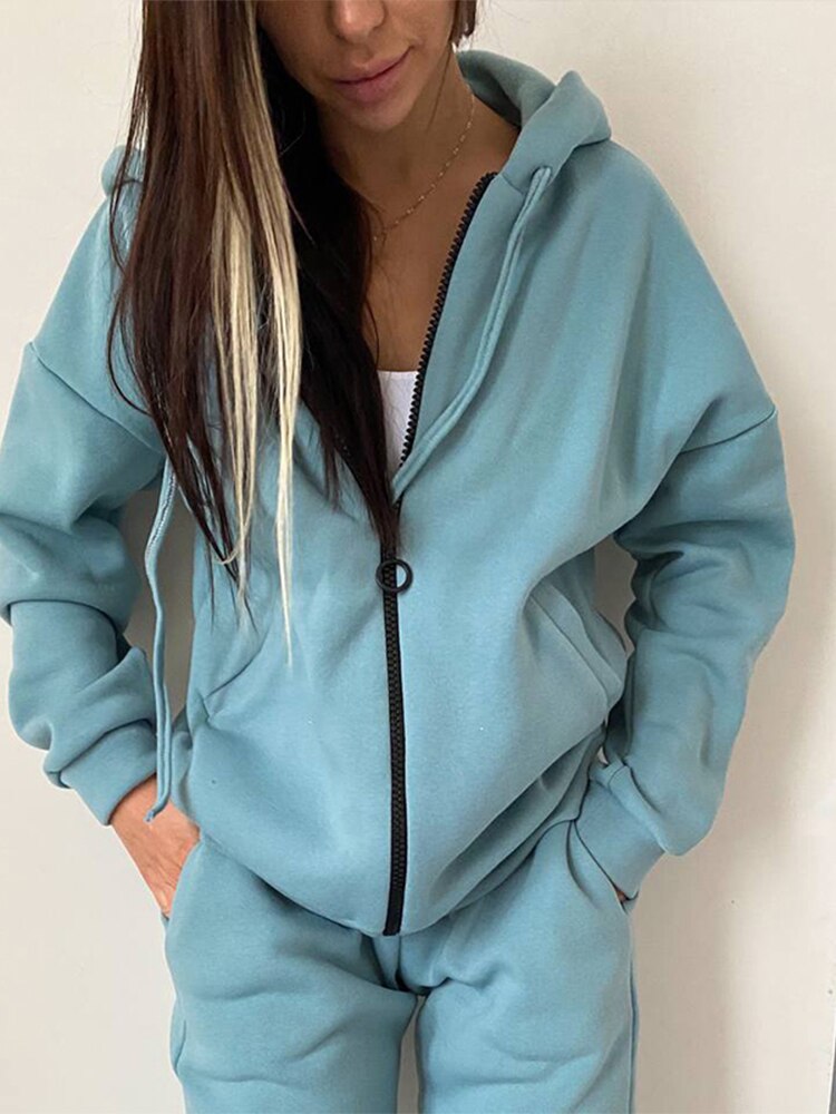 Frau in hellblauem Kapuzenpullover und Jogginghose, Freizeitmode, bequeme Damenbekleidung.