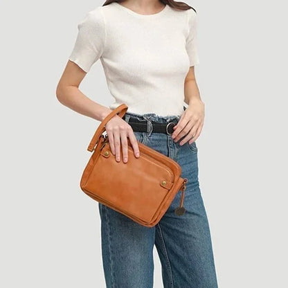 Frau mit brauner Leder-Crossbody-Tasche, lässig, modisch, ideal für Alltag und Reisen.