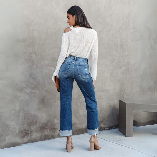 Frau in blauer Jeans und weißem Pullover, Rückansicht, modisch, lässig, Streetstyle.