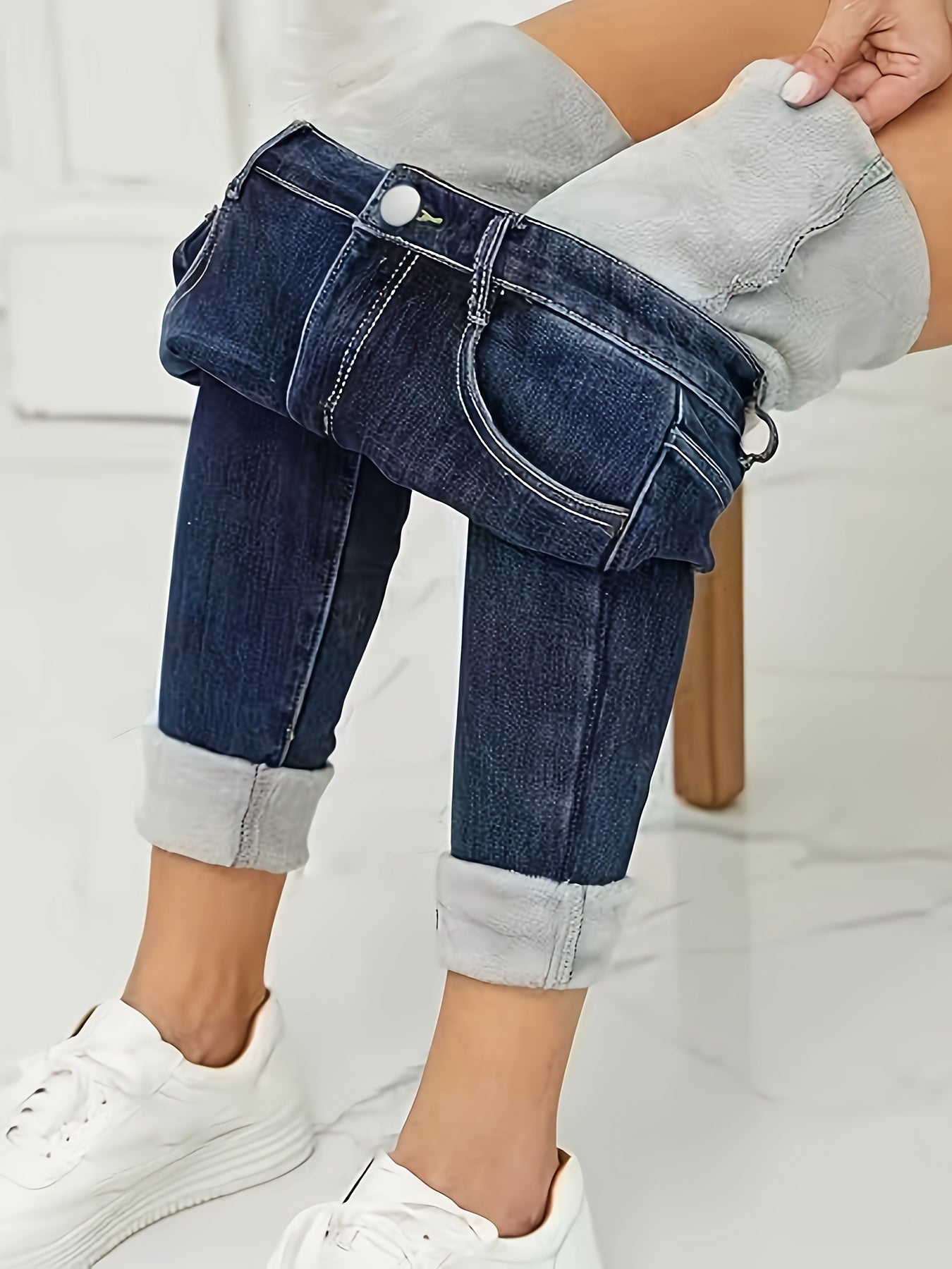 Damenjeans mit umgeschlagenem Saum, dunkelblau, hoher Bund, modisch, bequem, Freizeitkleidung.