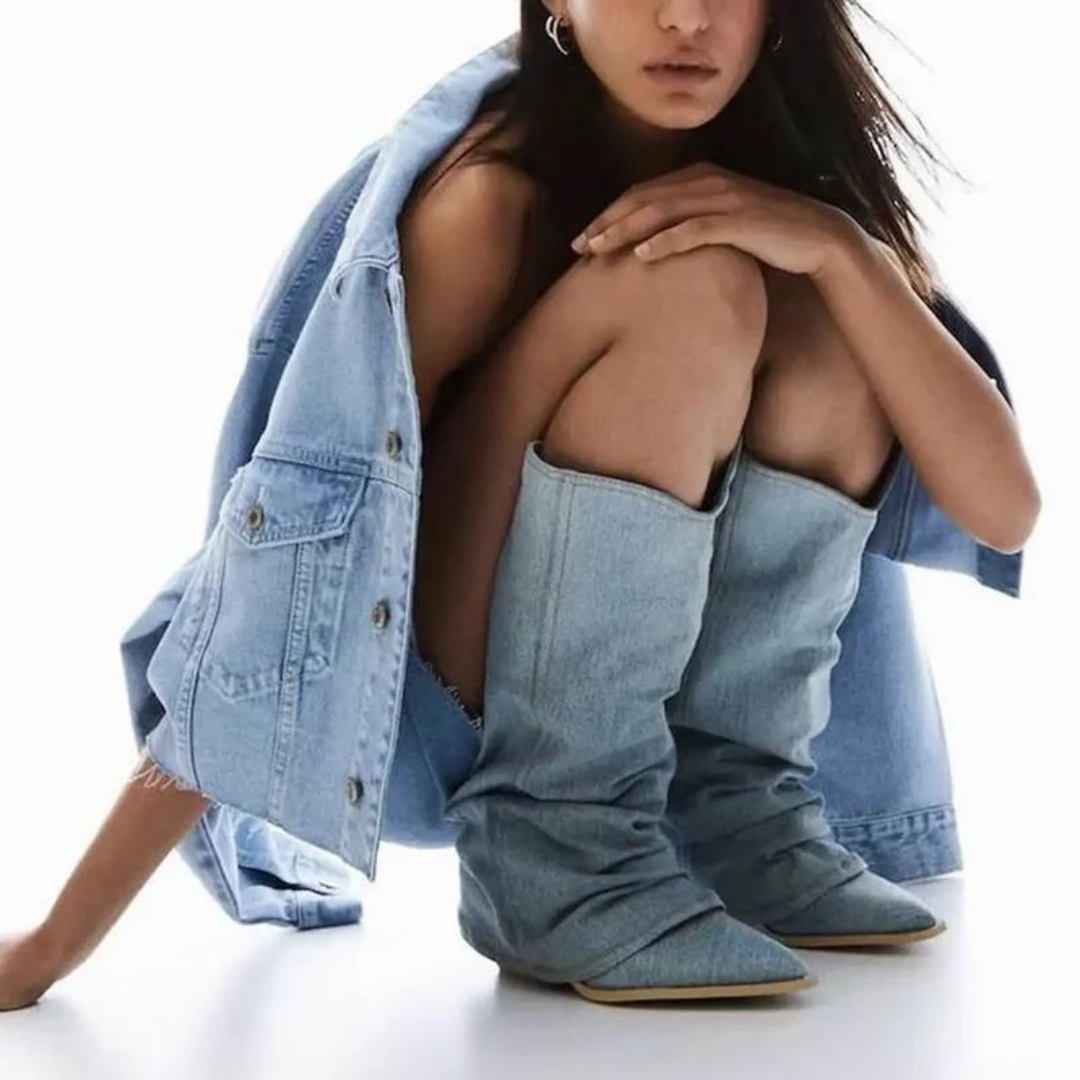 Frau in blauer Jeansjacke und Jeansstiefeln, modisch, lässig, Streetwear-Look.
