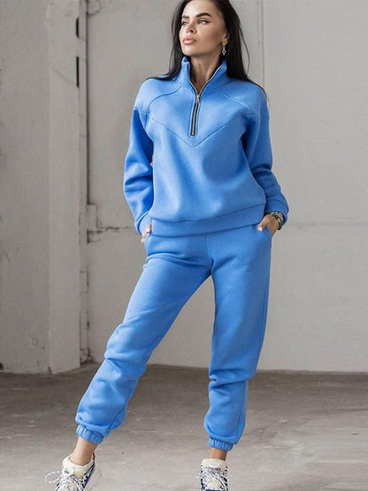 Frau in blauem Jogginganzug mit Reißverschluss, Freizeitmode, bequem, sportlich, modern.