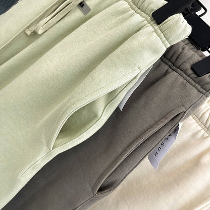 Drei Jogginghosen in Pastellfarben auf Kleiderbügeln, Baumwolle, bequem, modisch.