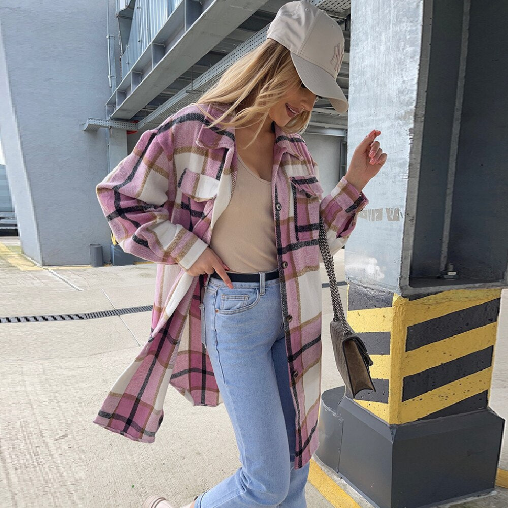Frau in karierter Oversize-Jacke, beige Top, Jeans, Baseballkappe, urbane Mode, Straße.