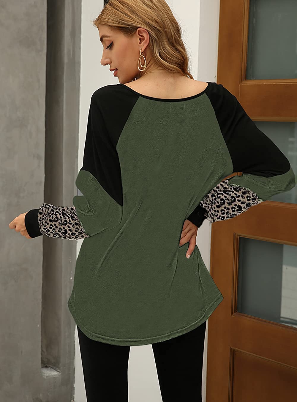 Frau in grünem Langarmshirt mit Leopardenmuster, lässige Damenmode, Herbstkollektion.
