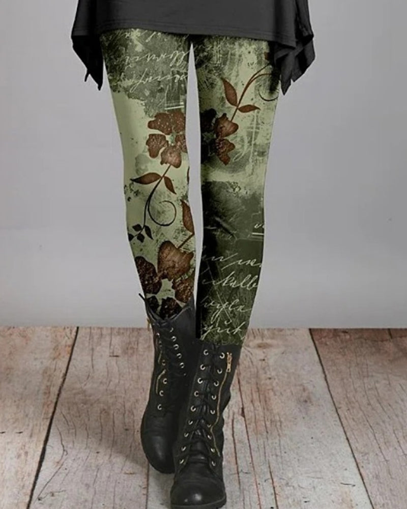 Grüne Leggings mit Blumenmuster, kombiniert mit schwarzen Stiefeln auf Holzboden.