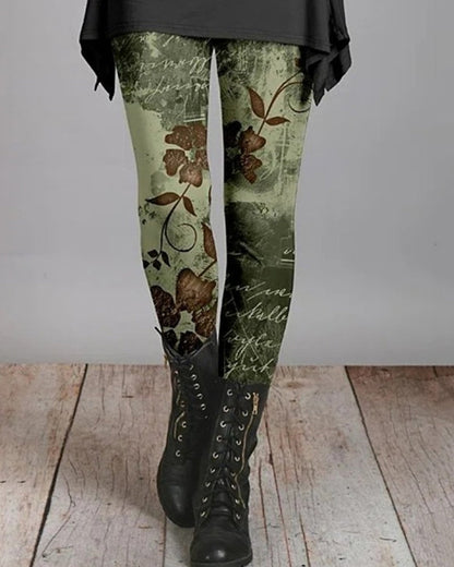 Grüne Leggings mit Blumenmuster, kombiniert mit schwarzen Stiefeln auf Holzboden.