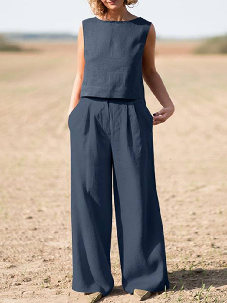 Frau in dunkelblauem Leinen-Zweiteiler, ärmelloses Oberteil, weite Hose, Sommermode.