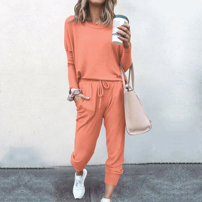 Frau in orangefarbenem Freizeitanzug mit Kaffeebecher und Handtasche, lässige Mode.