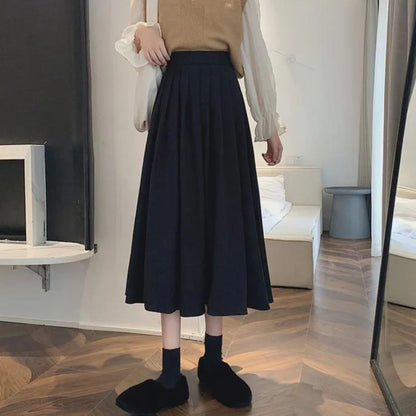 Damenmode: Eleganter schwarzer Midirock, Faltenrock, Herbstmode, stilvoll und zeitlos.
