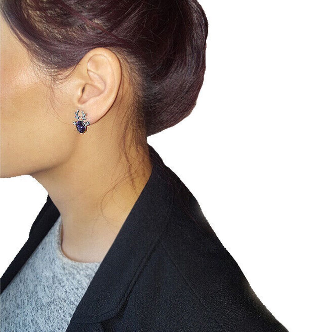 Frau mit blauen Ohrringen, silberne Fassung, elegantes Schmuckdesign, Nahaufnahme.