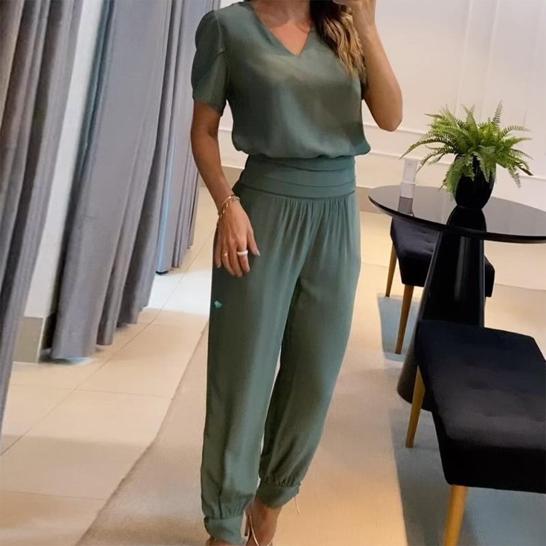Frau in grünem Satinanzug, V-Ausschnitt, elastische Taille, elegantes Design, moderne Mode.