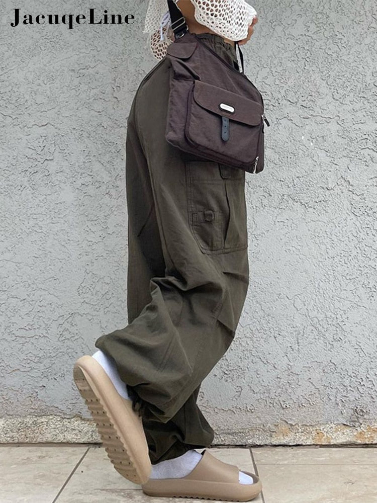 Frau in olivgrüner Cargohose, braune Umhängetasche, beige Sandalen, lässiger Streetwear-Look.