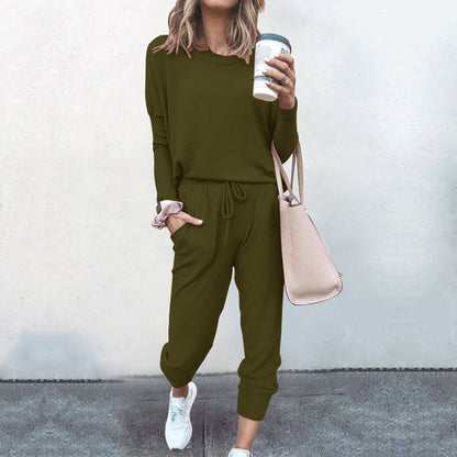 Frau in olivgrünem Jogginganzug mit Kaffeebecher und beiger Tasche, lässige Mode.