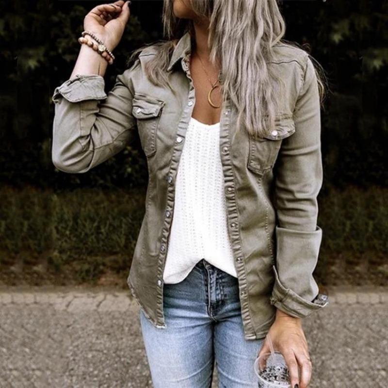 Frau in olivgrüner Jeansjacke, weißem Top und blauer Jeans, lässiger Herbstlook.