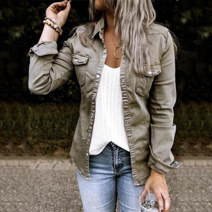 Frau in olivgrüner Jeansjacke, weißem Top und blauer Jeans, lässiger Herbstlook.