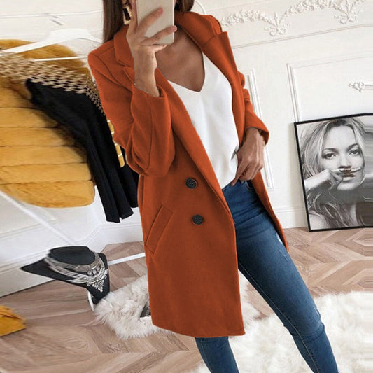 Frau in orangefarbenem Mantel, weißem Top, blauer Jeans, modernes Wohnzimmer, modisch.