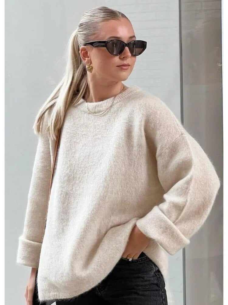 Frau in cremefarbenem Oversize-Pullover, lange Ärmel, Herbstmode, elegante Streetwear.