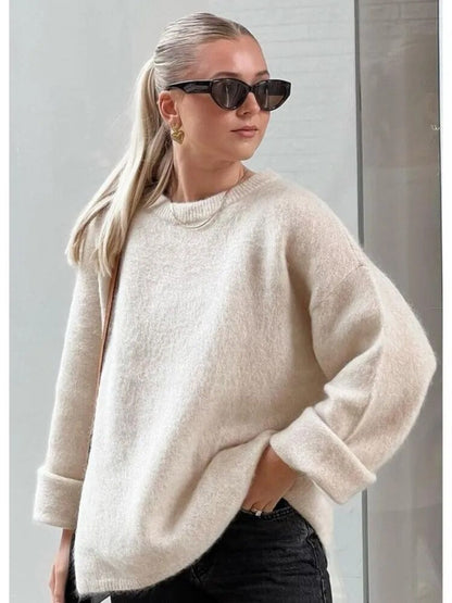 Frau in cremefarbenem Oversize-Pullover, lange Ärmel, Herbstmode, elegante Streetwear.