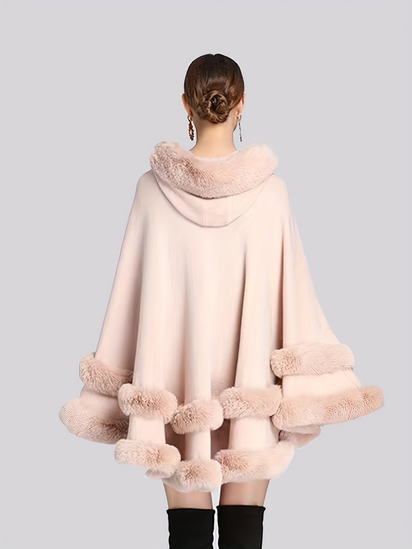 Frau in rosa Umhang mit Kunstpelzbesatz, elegantes Winteroutfit, Rückansicht.