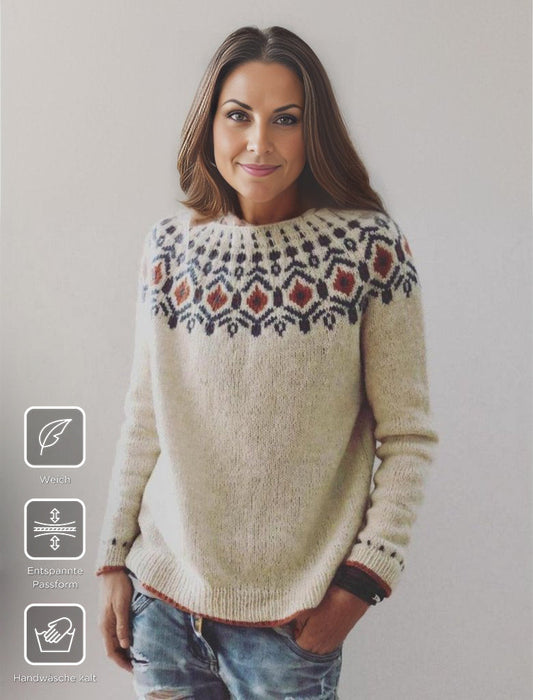 Frau in cremefarbenem Norwegerpullover mit Muster, weiches Material, entspannte Passform.