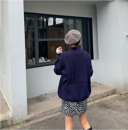 Frau in lila Strickpullover und grauem Barett vor modernem Gebäude, modisch, urban.