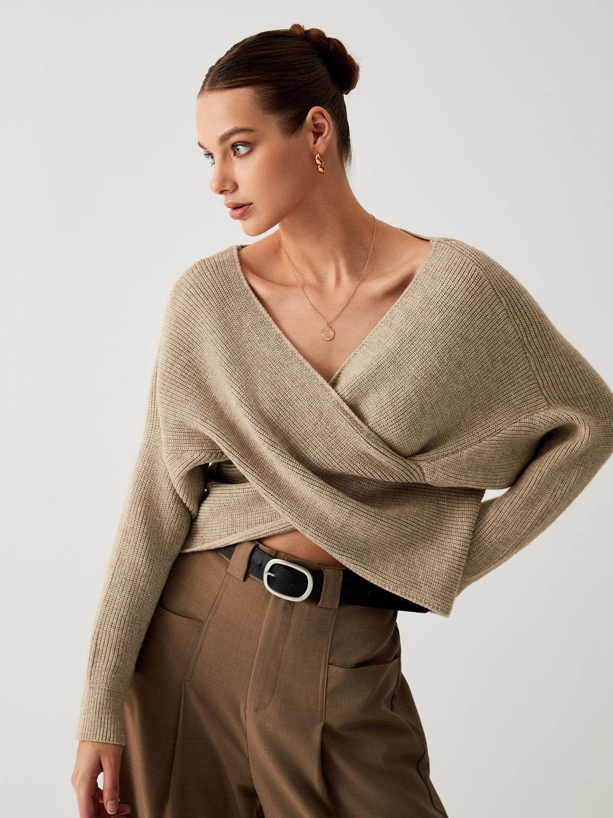 Frau in beigem Strickpullover, braune Hose, eleganter Look, Mode, Herbstkleidung.