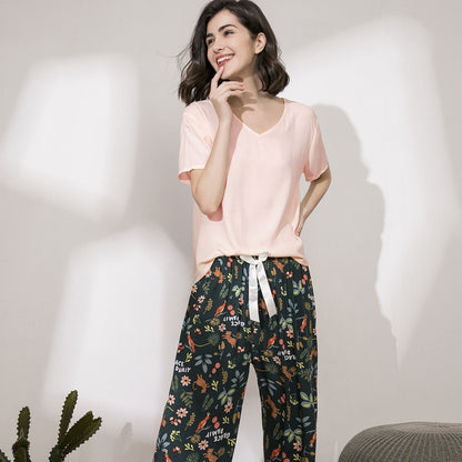 Frau in rosa T-Shirt und geblümter Hose, lächelnd, Freizeitkleidung, modisch, bequem.