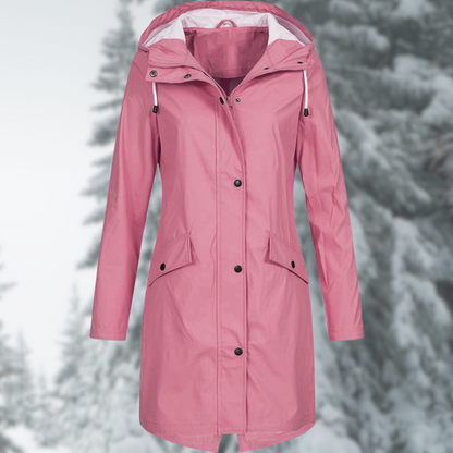 Rosa Damen-Regenmantel mit Kapuze, wasserdicht, Wintermode, vor verschneitem Waldhintergrund.