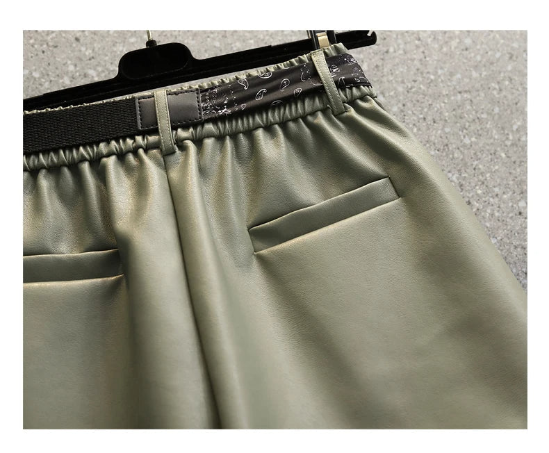 Grüne Lederhose mit elastischem Bund und Taschen, modische Damenbekleidung, Nahaufnahme.