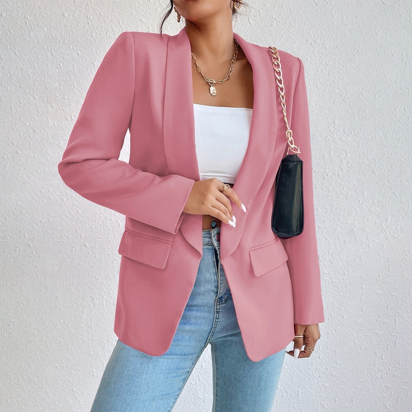 Frau in rosa Blazer, weißem Top, blauer Jeans, schwarze Tasche, modisch, elegant, Damenmode.