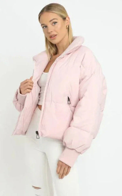 Frau in rosa Daunenjacke, weißes Top und Hose, modische Winterkleidung, Damenmode.