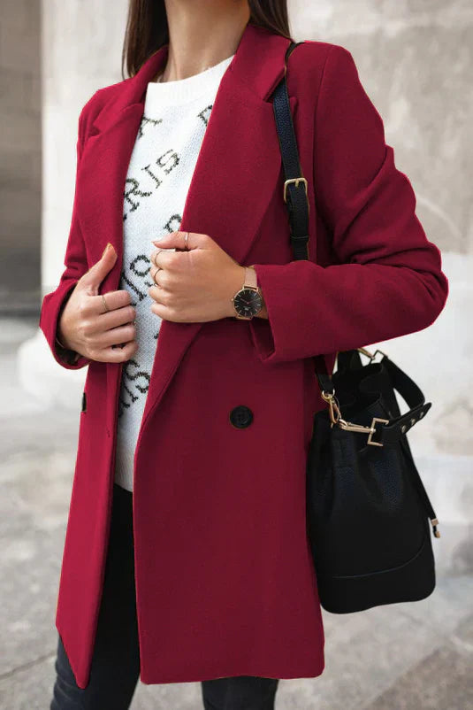 Frau in rotem Mantel, weißem Pullover, schwarzer Tasche, Armbanduhr; modische Herbstkleidung.